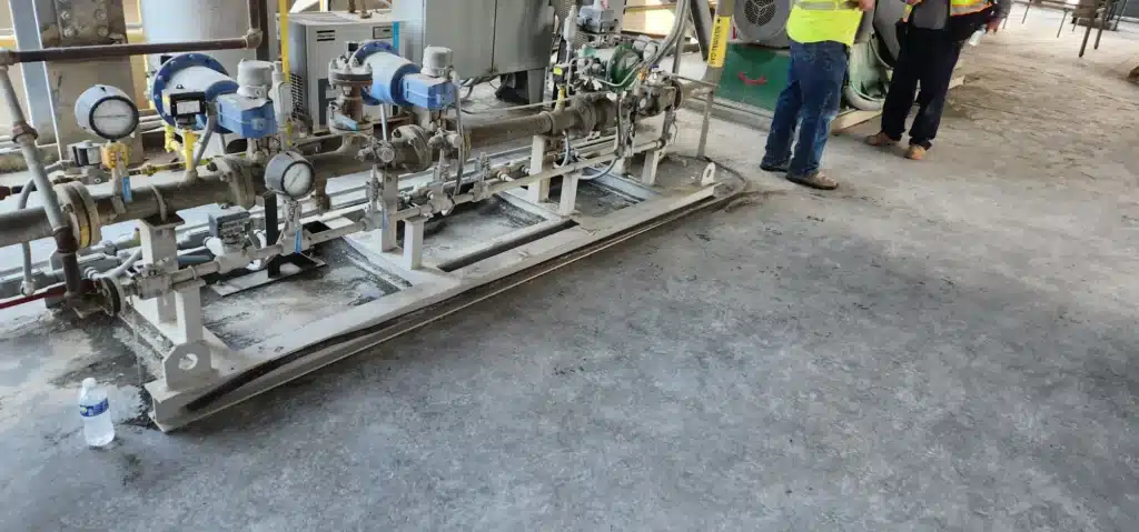 Combustion technicians inspecting a horizontal fuel valve train skid during an NFPA safety audit.